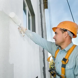 Professionelle Malerarbeiten an der Fassade wird Dispersionsfarbe mit einer Rolle aufgetragen. - Professionelle Malerarbeiten an der Fassade wird Dispersionsfarbe mit einer Rolle aufgetragen.